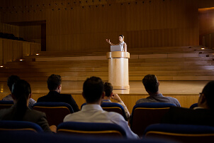 Speaker on stage in a conference auditorium