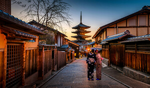 A narrow Japanese street at dusk with traditional wooden buildings